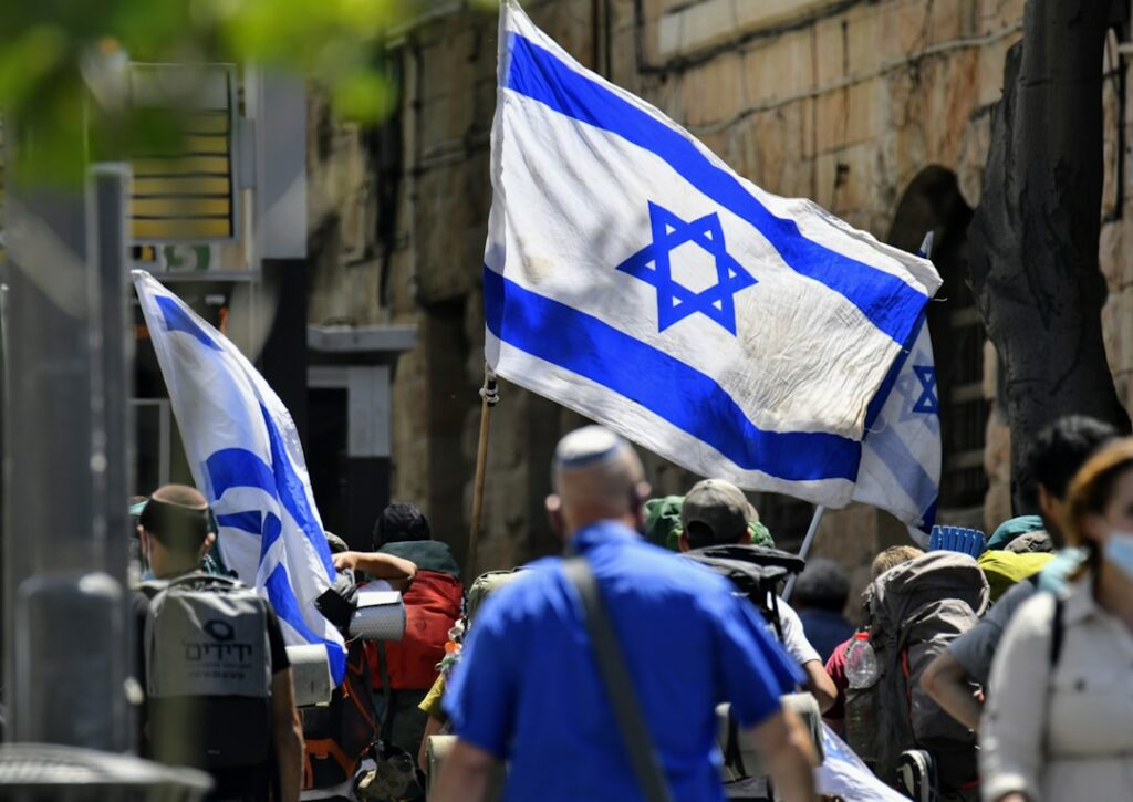 Toy soldiers stand near american and israeli flags.